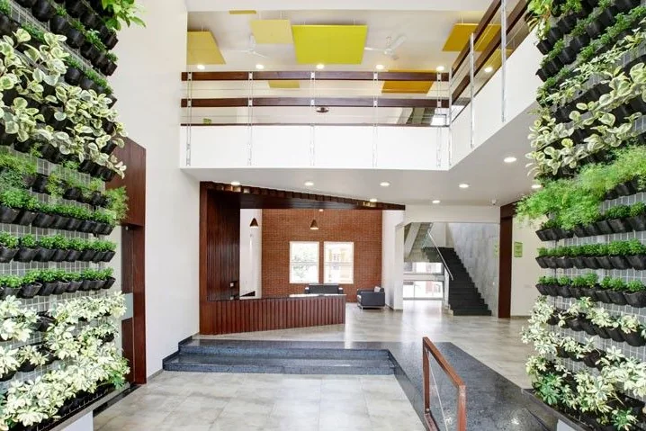 A green wall in the lobby at Vaishnavi Commune